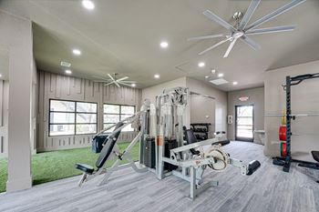 Fitness center with cardio equipment and grassy area  at Carmel Creekside, Fort Worth, 76137